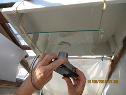 Photo of me taking a photo of the underside of a moth resting on a glass pain we suspended on the underside of a tray